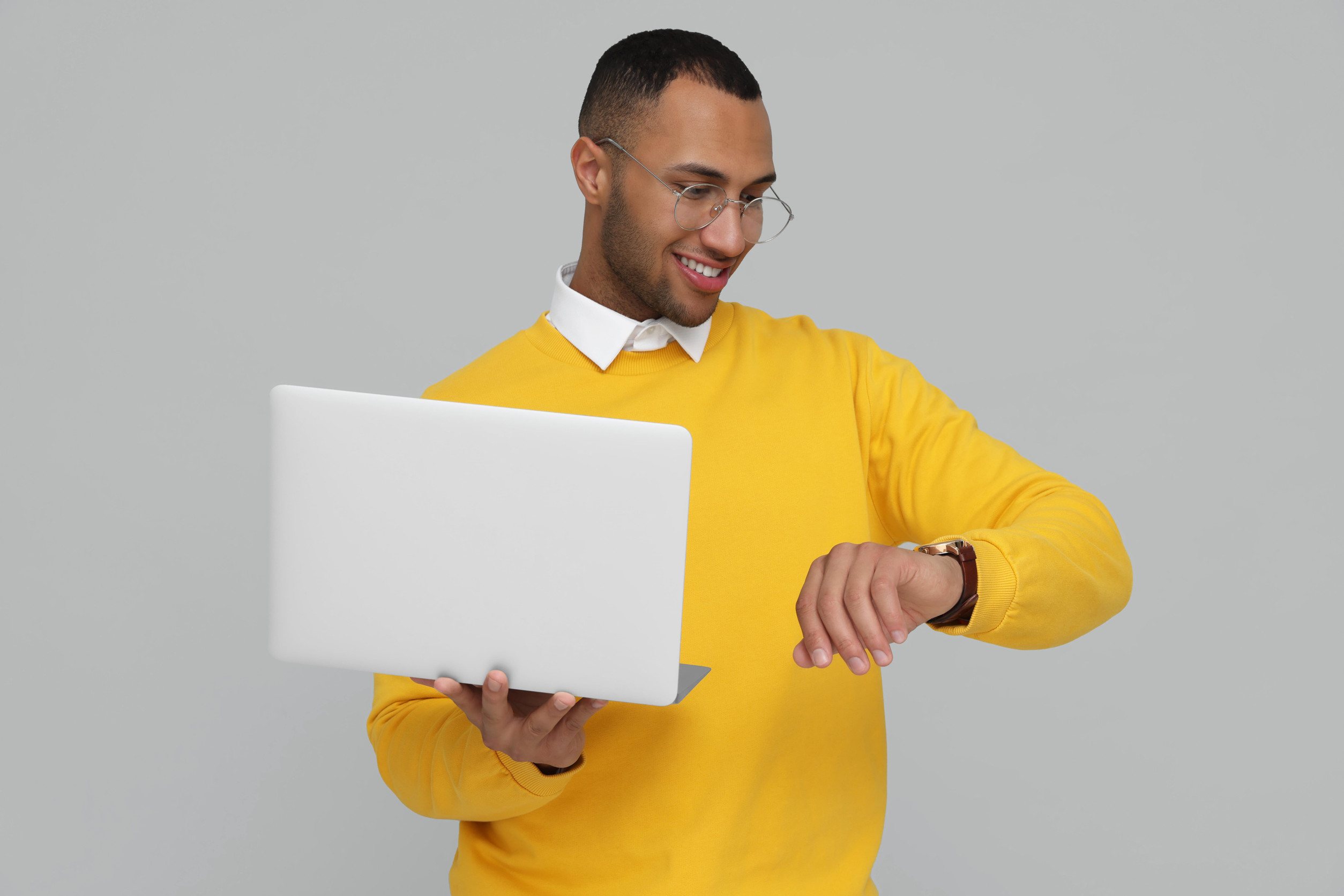 Happy Young Man With Laptop Checking Time